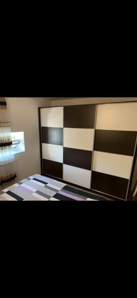 Bedroom with a large built-in wardrobe and a bed.