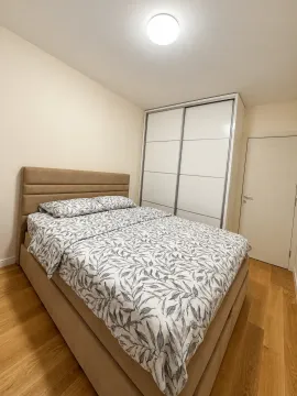 Furnished bedroom with a double bed, wardrobe, and wooden flooring. - image 2
