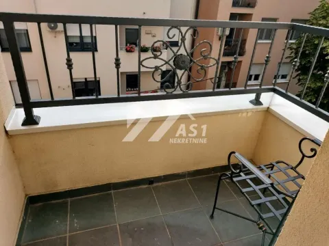 Manji balkon sa crnom metalnom ogradom i stolicom. - image 9
