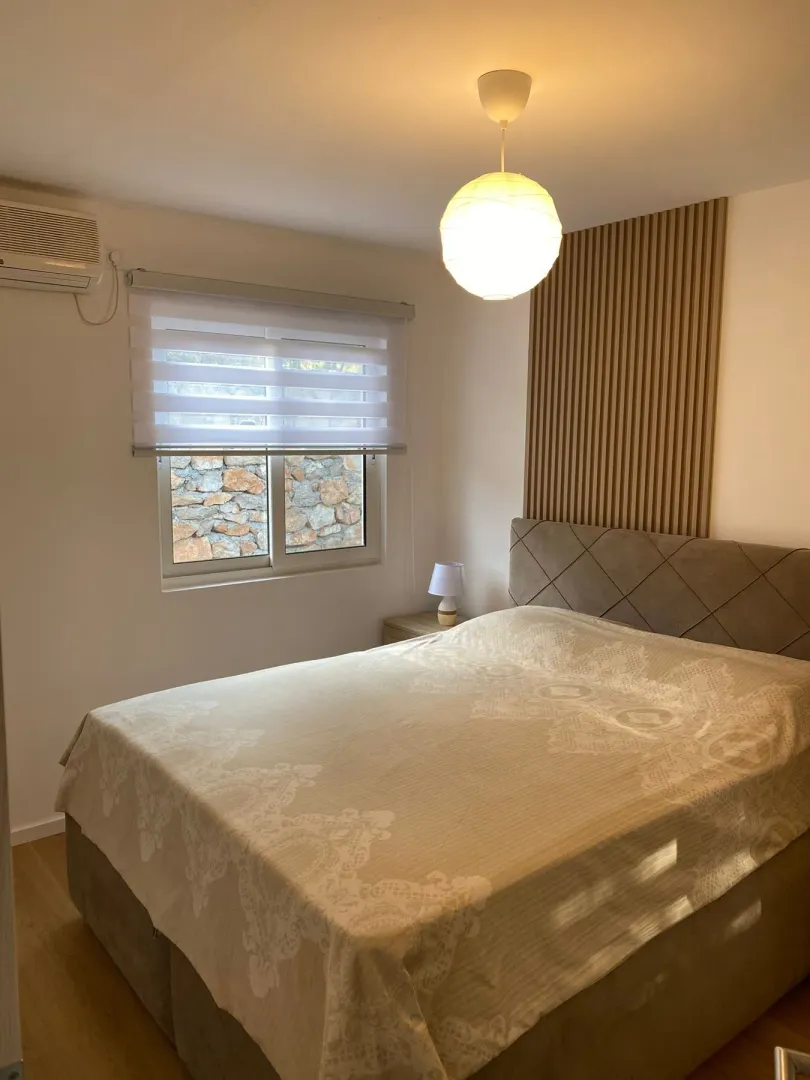 Furnished bedroom with a double bed and a decorative wall panel.