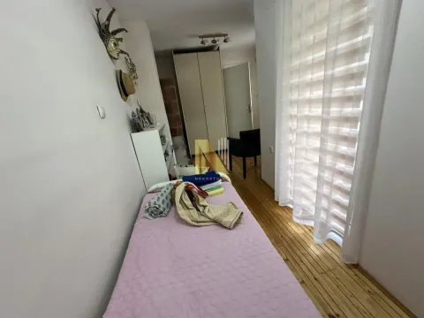 Manja spavaća soba sa krevetom i drvenim podom. - image 11