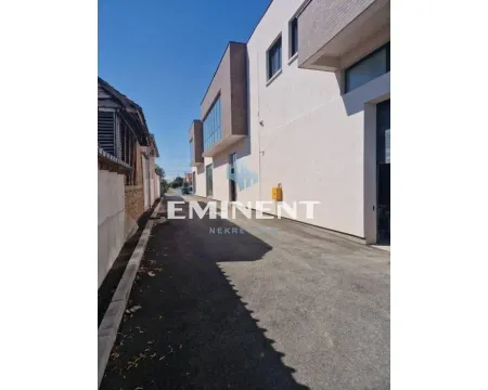 View of the driveway and the exterior of the building with an asphalt road. - image 13