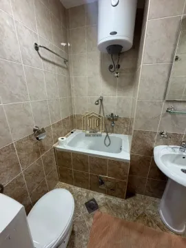 Manje kupatilo obloženo keramičkim pločicama sa kadom, lavaboom i bojlerom. - image 15
