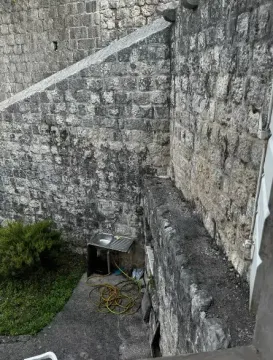 View of the exterior yard area with stone walls and a sink. - image 5