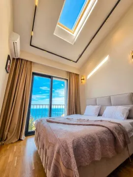 Bedroom with a double bed, skylight, and balcony door offering a sea view. - image 13