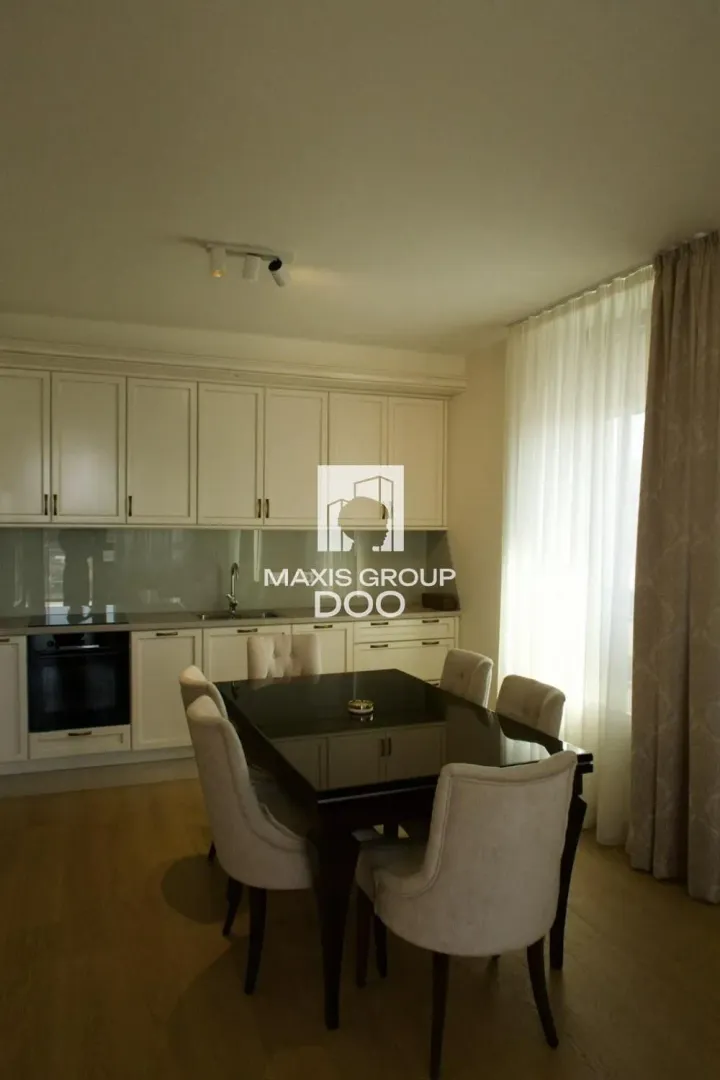 Kitchen with dining area equipped with white cabinetry and a black table with chairs.