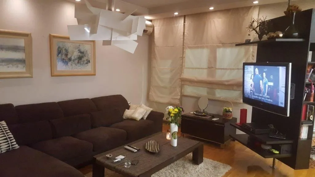 Cozy living room with a brown sectional sofa and a TV.