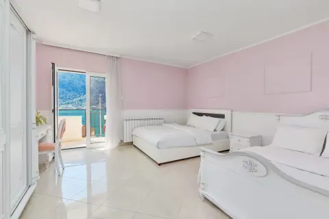 Spacious bedroom in pink and white tones with access to a balcony and sea view. - image 8