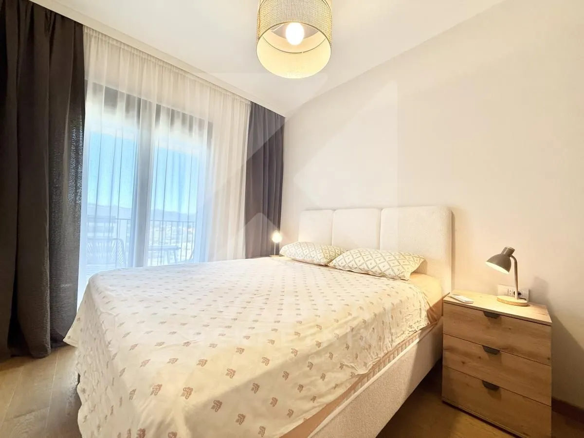 Furnished bedroom with a double bed, bedside table, and access to the terrace.