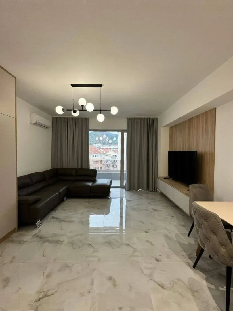 Living room with sofa, TV and dining table.