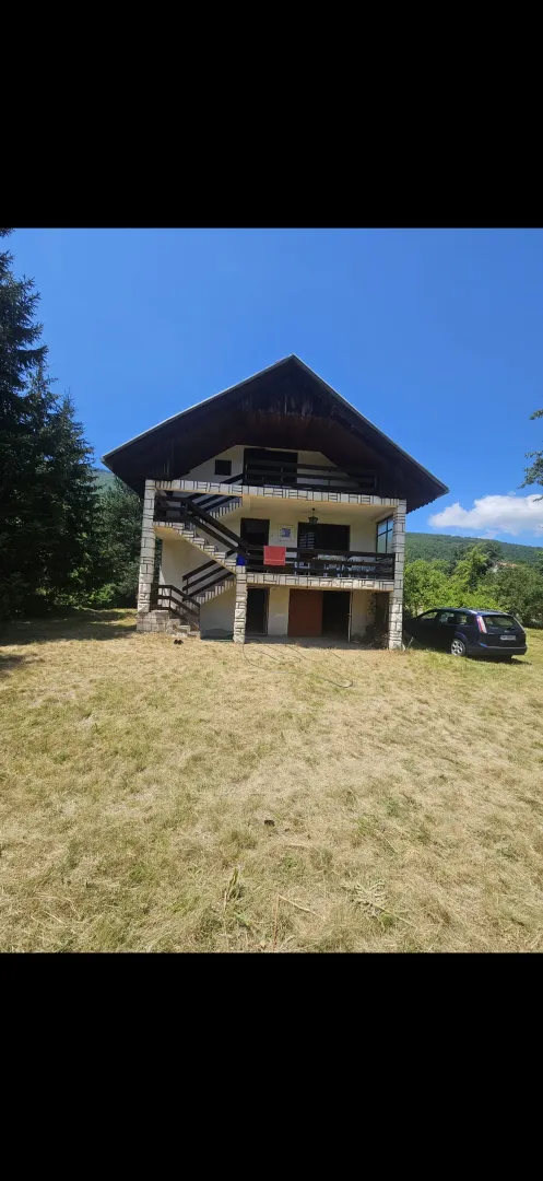 Spoljašnji izgled kuće sa dvorištem i spoljnim stepeništem.