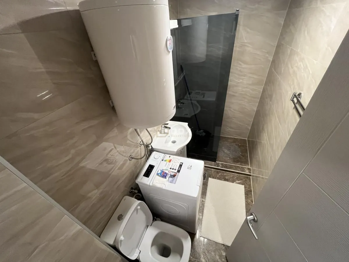 Manje kupatilo sa tuš kabinom, wc šoljom, umivaonikom i bojlerom.