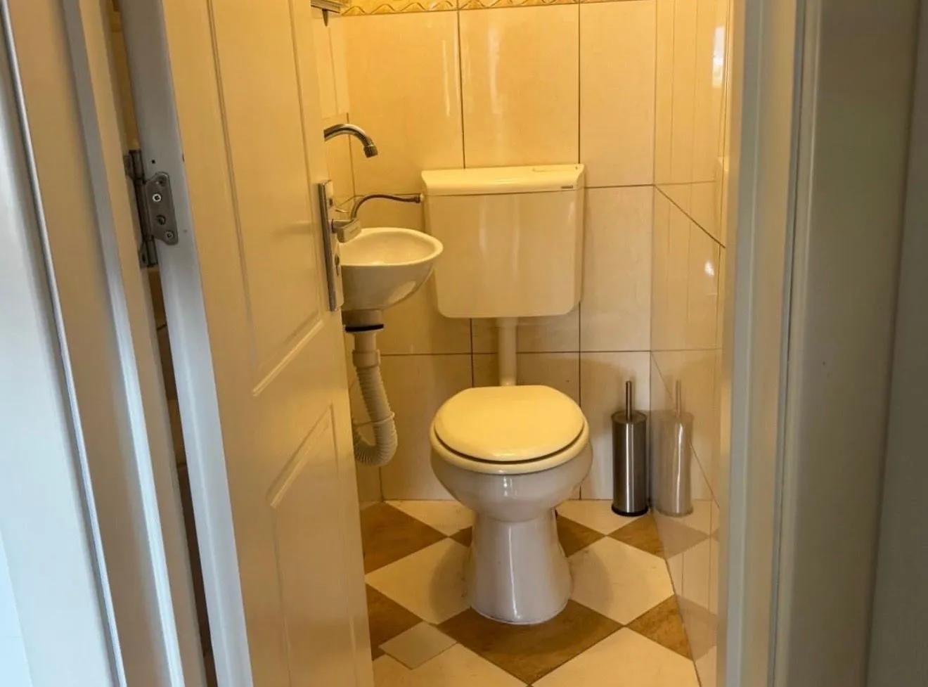 Manje kupatilo sa WC šoljom i umivaonikom.