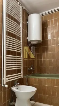 Smaller bathroom with a bathtub, bidet, and water heater. - image 10