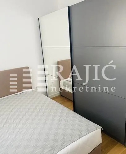 Furnished bedroom with a double bed and a large wardrobe with a mirror.