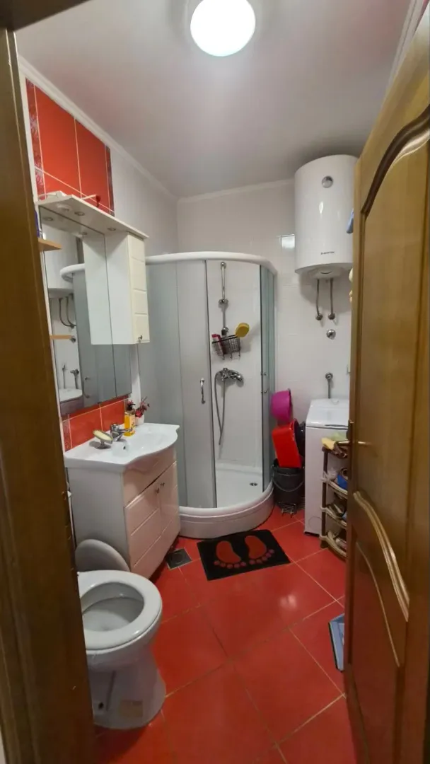 Manje kupatilo sa tuš kabinom, umivaonikom, WC šoljom i bojlerom.