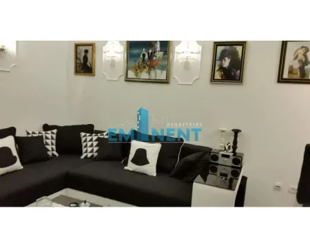 Living room with a black corner sofa and paintings on the wall. - image 4