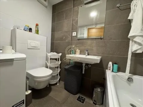 Bathroom equipped with a washbasin, toilet, bathtub, and washing machine. - image 6