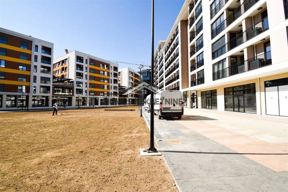 View of the exterior of the residential complex with a landscaped yard and sidewalk.