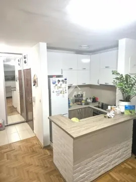 Manja kuhinja sa šankom i drvenim elementima u sklopu stana. - image 5