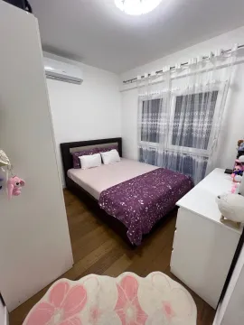 Namještena spavaća soba sa bračnim krevetom, bijelom komodom i klima uređajem. - image 9