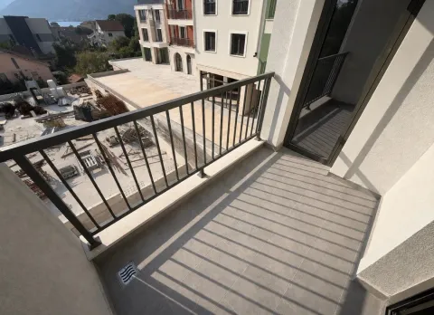 Manji balkon sa metalnom ogradom i pogledom na gradilište i okolne objekte. - image 5