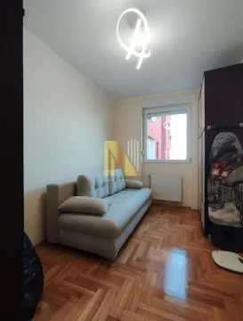 Manja dnevna soba sa garniturom i parketom na podu. - image 9