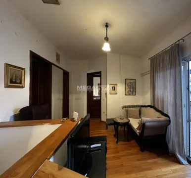 Living room with a sofa, small table and hardwood flooring. - image 20