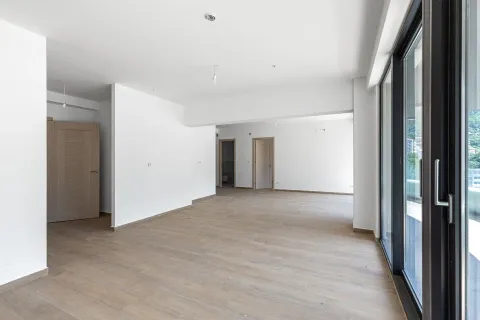 Prazna neopremljena prostorija sa drvenim podom i velikim staklenim balkonskim vratima. - image 7