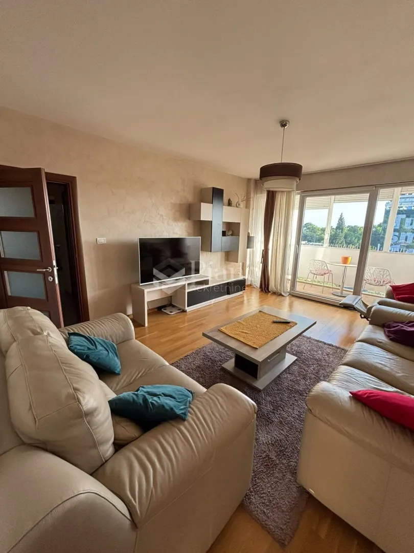 Living room with a sofa set, TV, and access to the terrace.