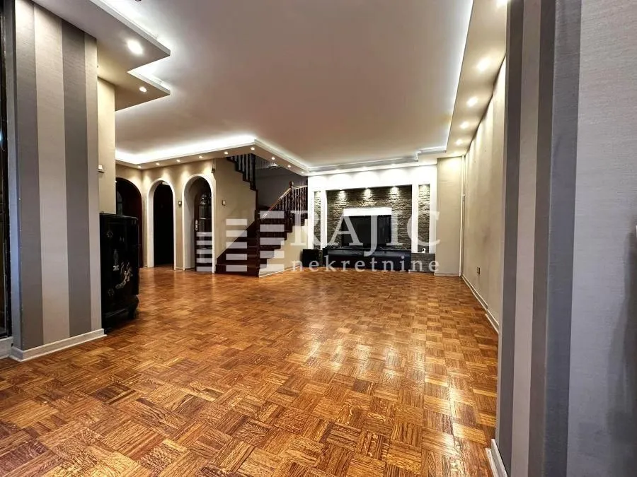 Spacious living room with parquet flooring and recessed ceiling lighting.