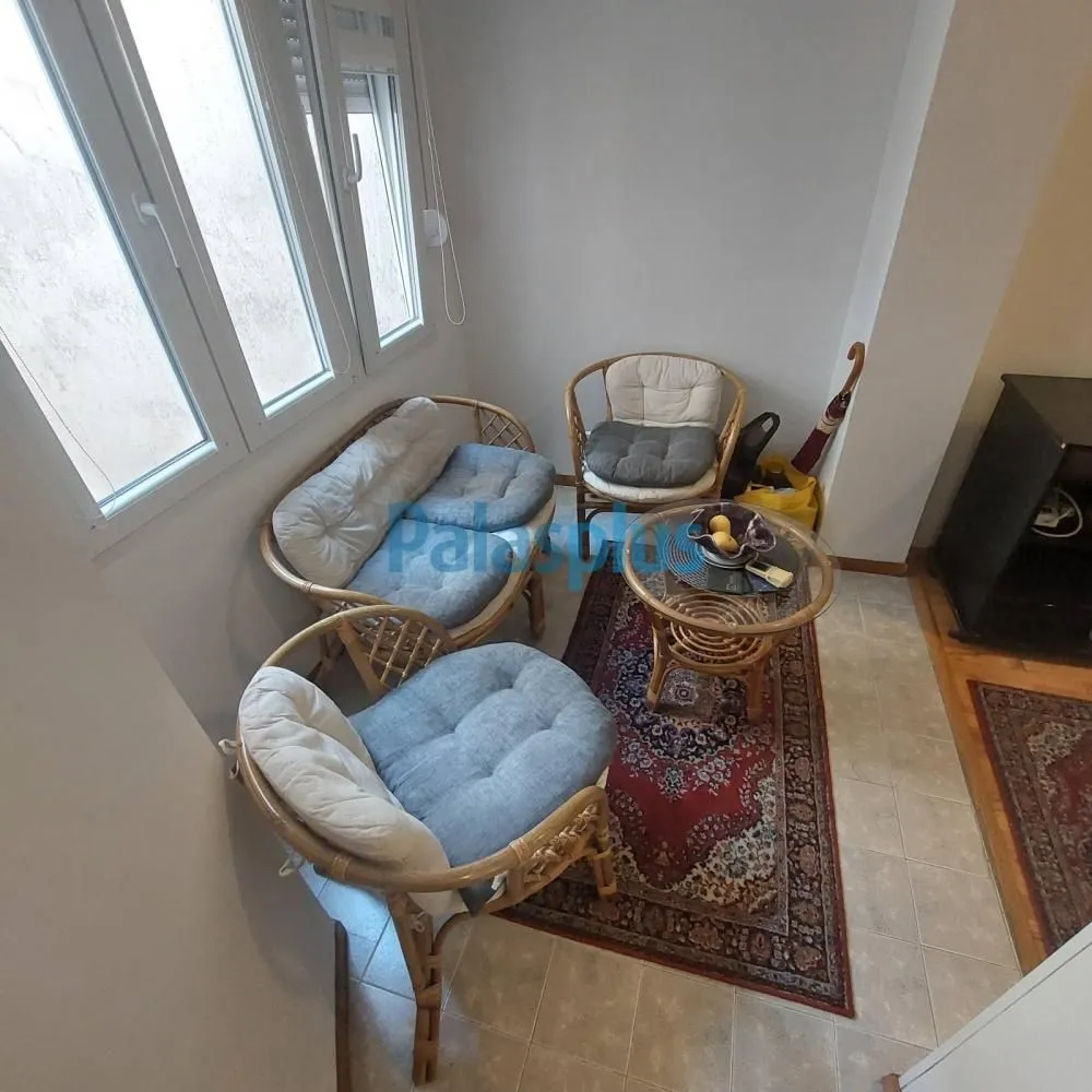 Small living room with rattan seating set and a small coffee table.