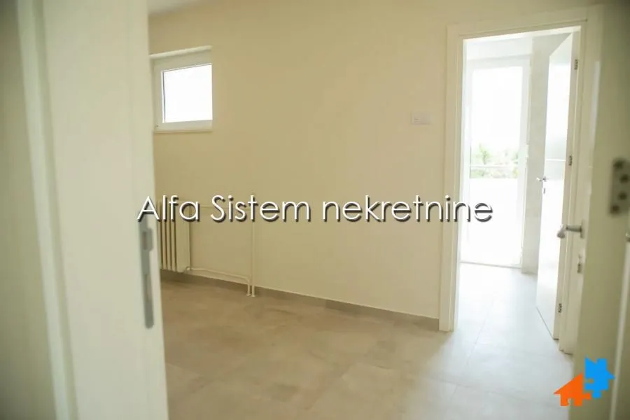 Empty room with light-colored walls and tiled flooring.