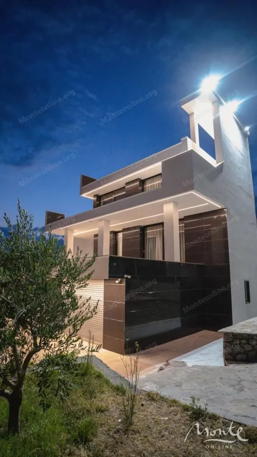 View of a modern villa with lighting at dusk.