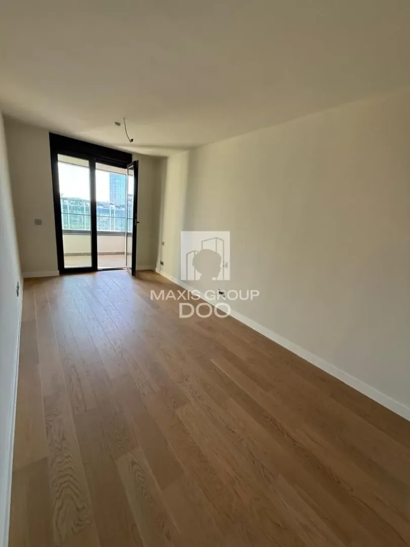 Empty room with wooden flooring and access to the terrace.