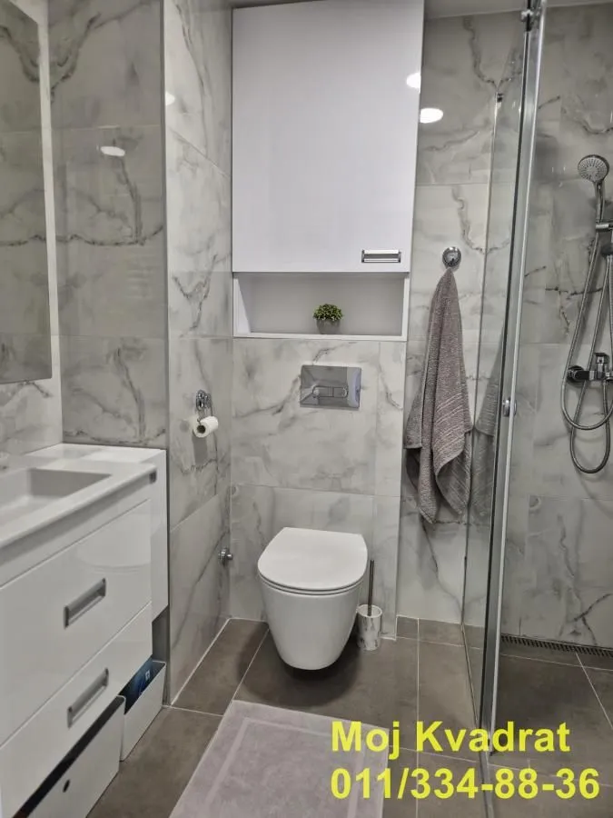 Modern bathroom equipped with a walk-in shower and marble-effect tiles.