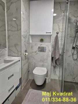 Modern bathroom equipped with a walk-in shower and marble-effect tiles. - image 10