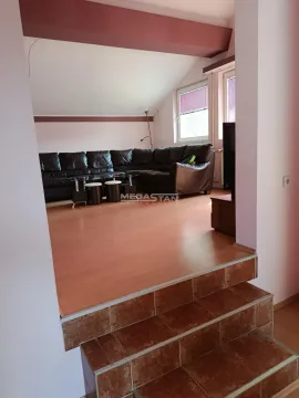 View of the living room with a sofa through a passage with stairs. - image 2