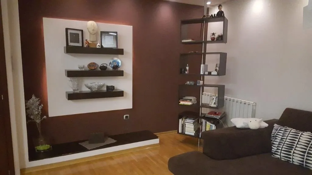 Living room featuring decorative shelving and a sofa.