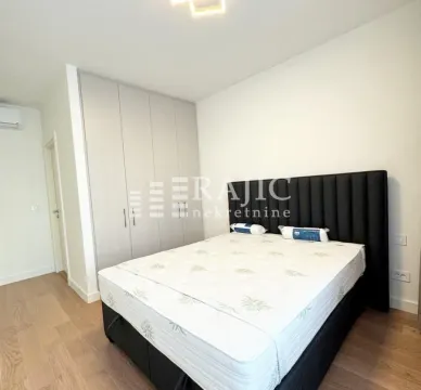 Modern bedroom with a double bed and built-in wardrobe. - image 11