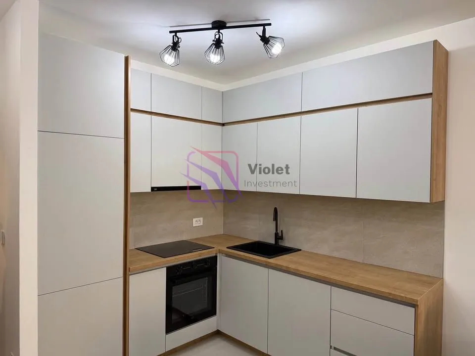 Modern kitchen with light cabinets and a wooden countertop.