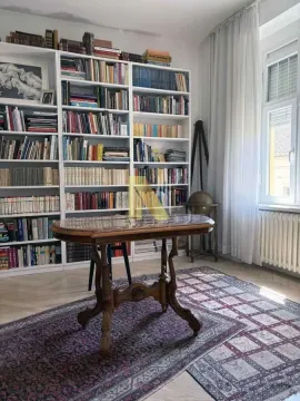 Dnevna soba sa velikom bibliotekom i drvenim stolom. - image 14