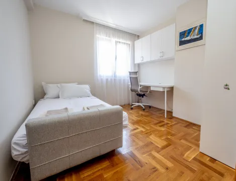 Spavaća soba sa krevetom, radnim stolom i prozorom. - image 8