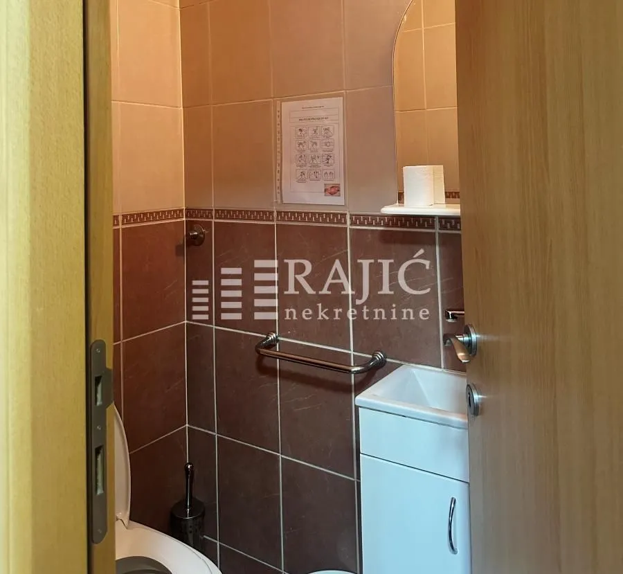 Smaller bathroom with a washbasin, mirror, and toilet.