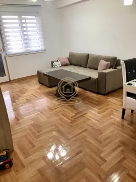 Dnevna soba sa garniturom za sedenje i drvenim podom. - image 3
