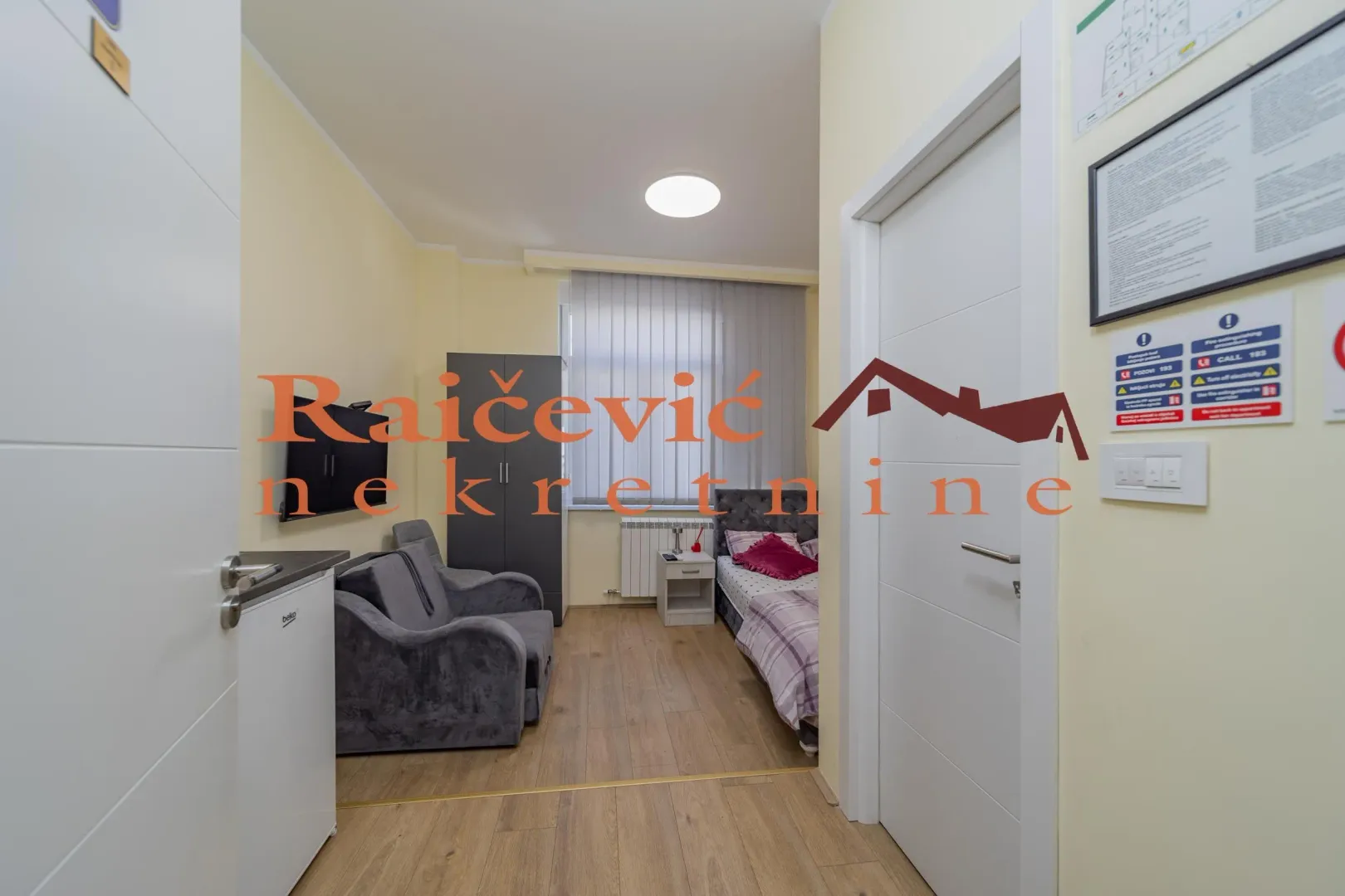 Pogled na manju spavaću sobu sa krevetom, foteljama i ormarom.