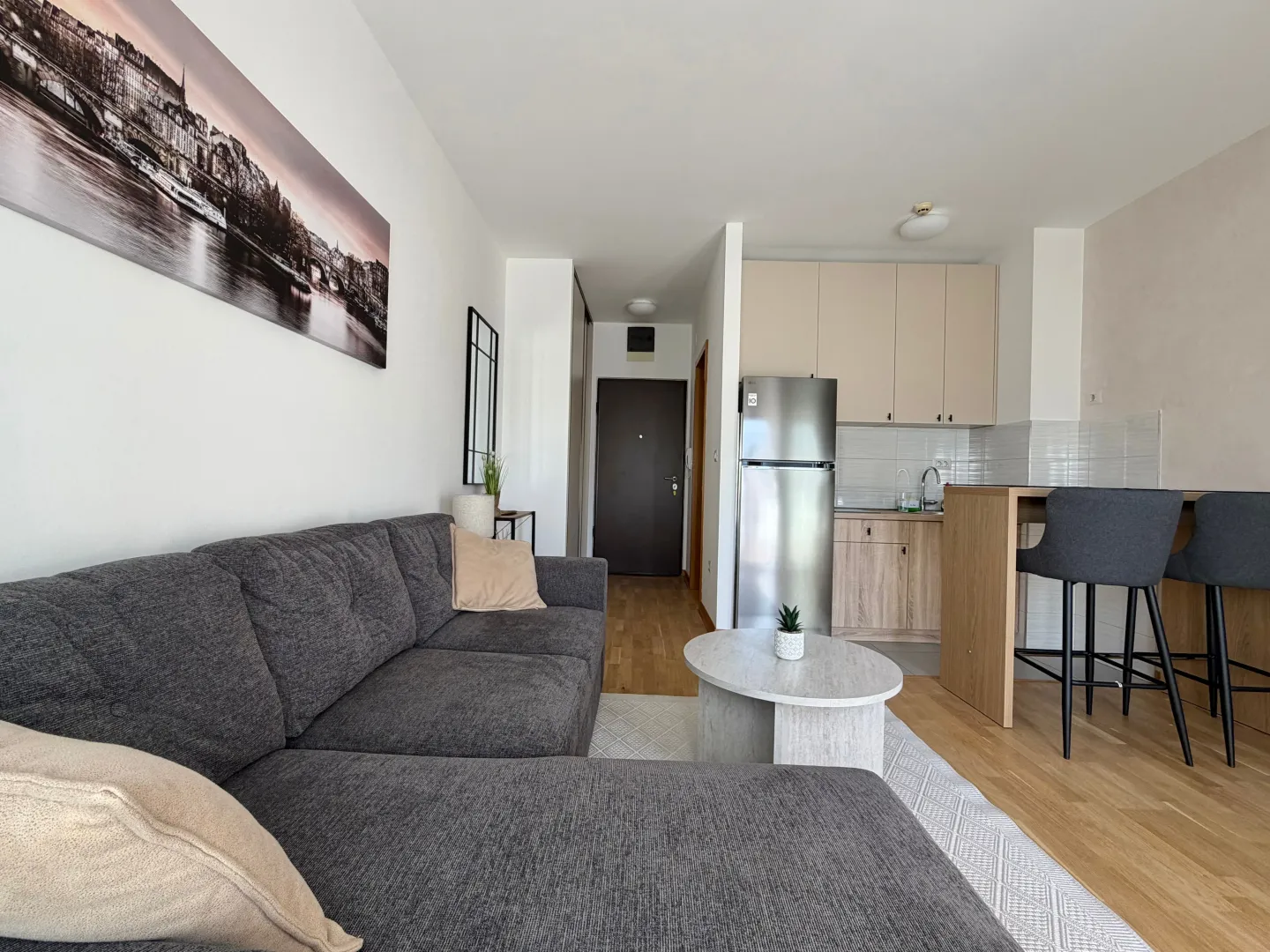 Living room with a sofa connected to the kitchen and dining bar.