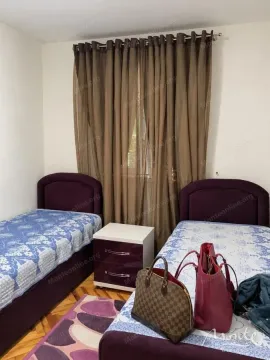 Bedroom with two single beds and a window with curtains. - image 3