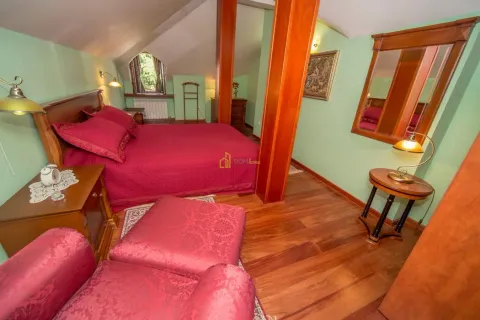 Spacious attic bedroom with a double bed and wooden furniture. - image 19