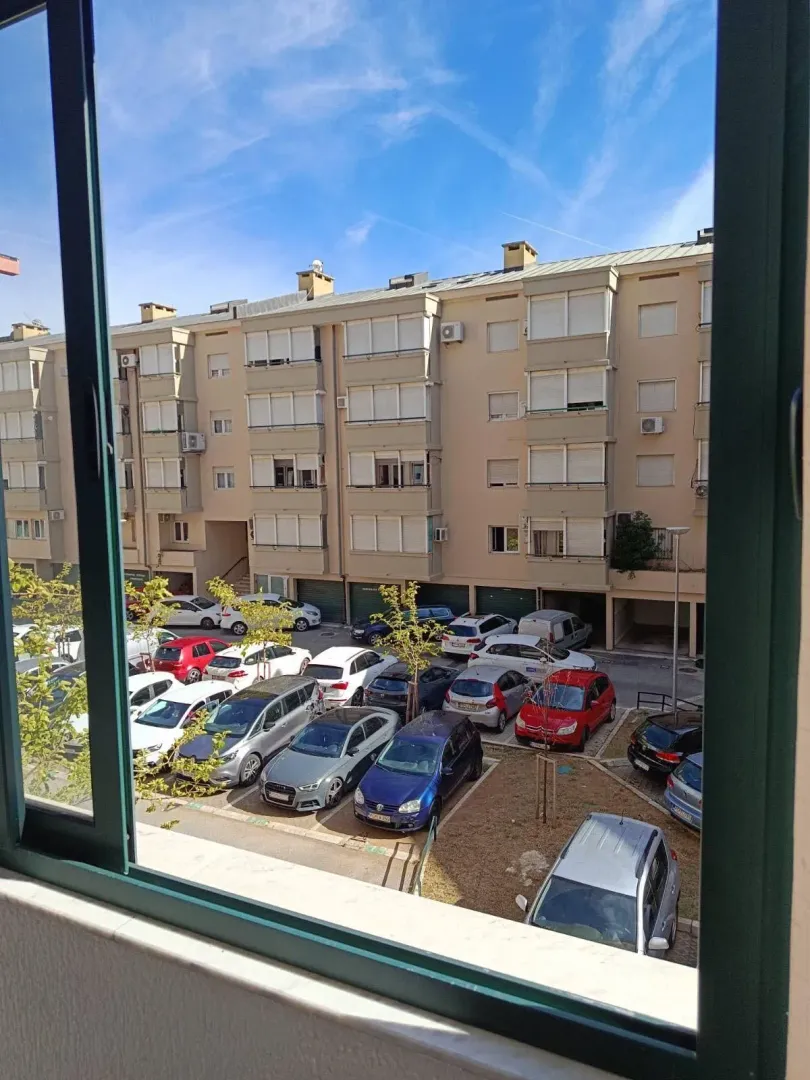 View through the window of surrounding buildings and a parking lot.